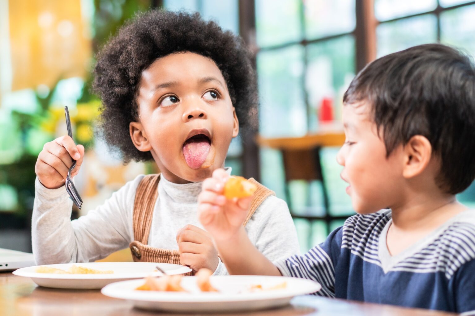 Helping Expose Your Child To New Foods playful kids eating snack in cafe restaurant