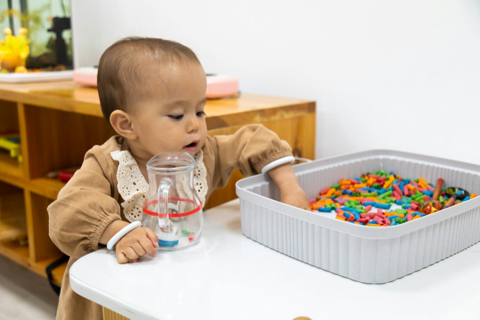 Navigating Sensory Issues: Comprehensive Strategies for Families and Caregivers Toddler playing sensory game with colored pasta