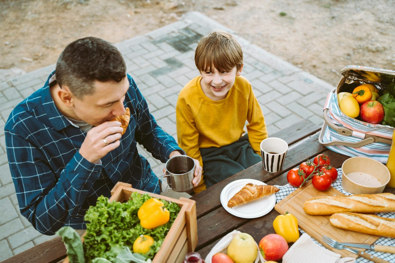 Child Choking Precautions: The Silent Risk Every Parent Should Be Aware Of Father dad and school kid boy child eating croissant picnic forest camping site with vegetables
