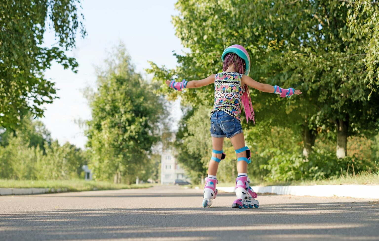 Kid tries to keep and not fall, for the first time standing on roller skates